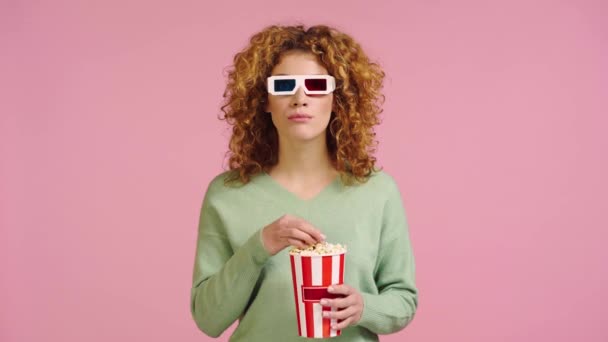 戴3D眼镜的阳性女性吃着用粉红隔离的爆米花 — 图库视频影像