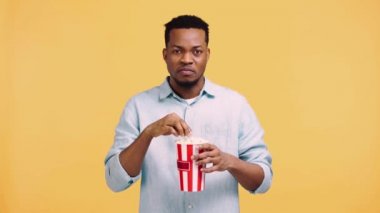 Afro-Amerikan adam sarı üzerine izole edilmiş bir film izliyor.