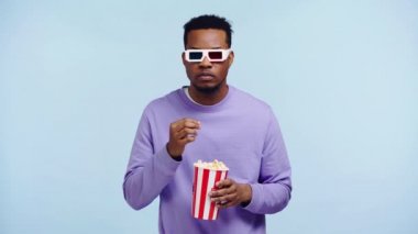Odaklanmış Afro-Amerikan adam mavi üzerine izlenmiş bir film izliyor.