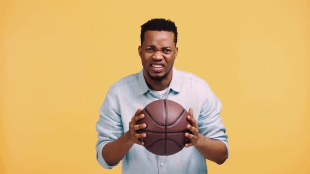 Αναστατωμένος Αφροαμερικάνος Βλέποντας Παιχνίδι Μπάσκετ Απομονωμένο Στο Κίτρινο — Αρχείο Βίντεο