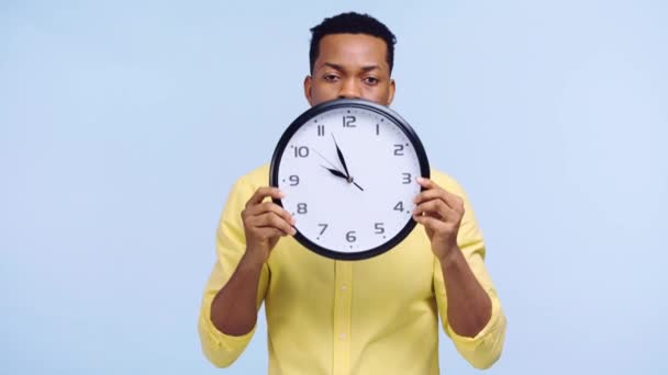 Zdenerwowany Afroamerykanin Człowiek Trzyma Zegar Odizolowany Niebiesko — Wideo stockowe