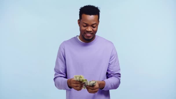Χαρούμενος Αφροαμερικάνος Που Μετράει Χρήματα Απομονωμένα Στο Μπλε — Αρχείο Βίντεο