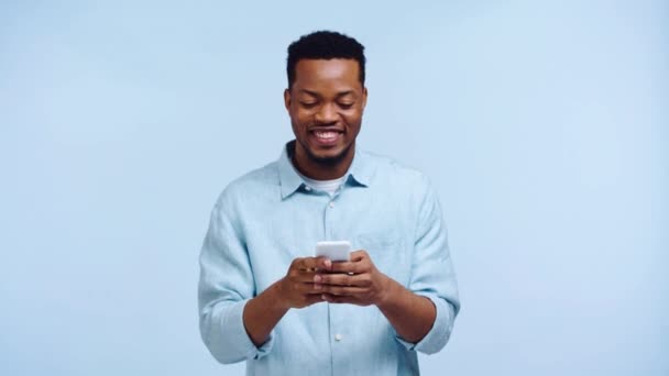 African American Man Chatting Smartphone Isolated Blue — Stock Video
