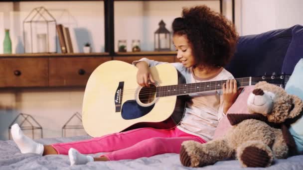 Criança Afro Americana Tocando Guitarra Acústica Cama — Vídeo de Stock