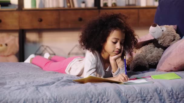 Enfant Afro Américain Faisant Ses Devoirs Lit Près Ours Peluche — Video