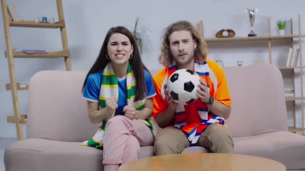不幸なサッカーファンの近くでお祝いする幸せな女性 — ストック動画