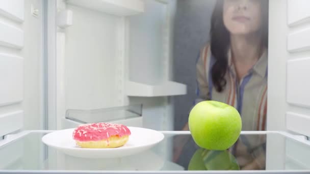 冷蔵庫からアップルを取って魅力的な女の子 — ストック動画