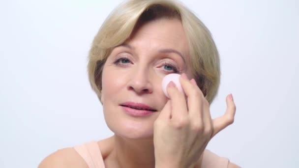 Mogen Kvinna Som Håller Makeup Puff Nära Ansiktet Isolerad Vit — Stockvideo