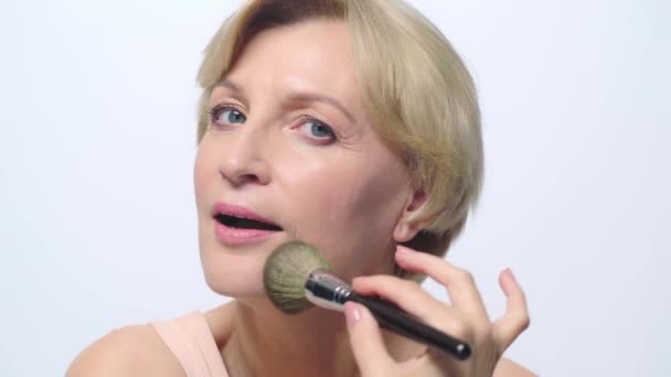 Reife Frau Anwendung Gesichtspuder Isoliert Auf Weiß — Stockvideo