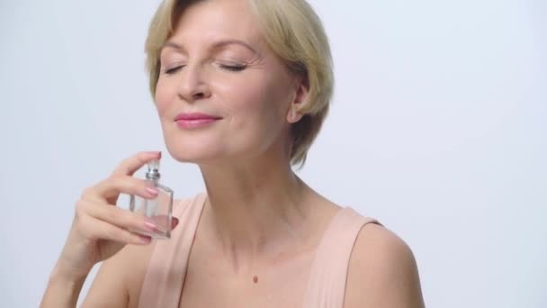 Mulher Com Olhos Fechados Pulverização Perfume Isolado Branco — Vídeo de Stock