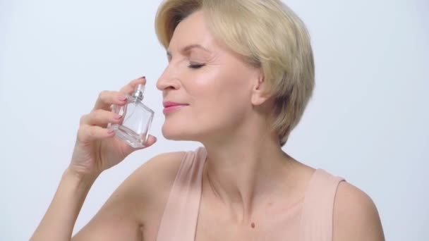 Mature Woman Smelling Perfume Isolated White — Stock Video