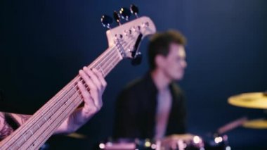 Davulcuyla şarkı söyleyen dövmeli gitaristin seçici odağı 