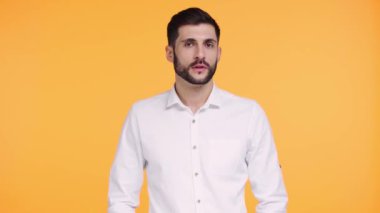 Yüze dokunan sinirli adam turuncu üzerine izole edilmiş. 