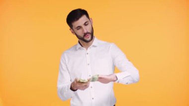 Turuncu üzerine izole edilmiş havadan para atan adam. 