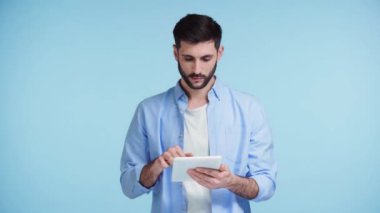 Adam mavi ekranlı dijital tableti işaret ediyor.