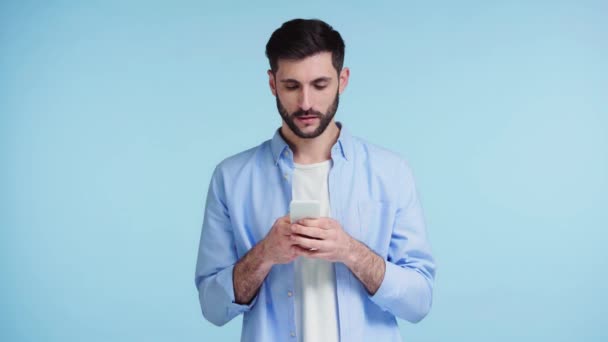 Hombre Barbudo Usando Teléfono Inteligente Aislado Azul — Vídeos de Stock