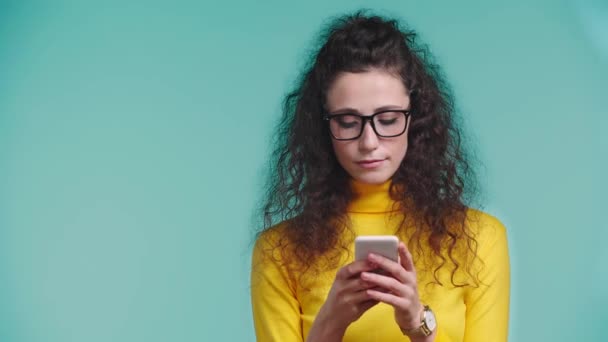 Mujer Sonriente Mostrando Teléfono Inteligente Aislado Turquesa — Vídeos de Stock