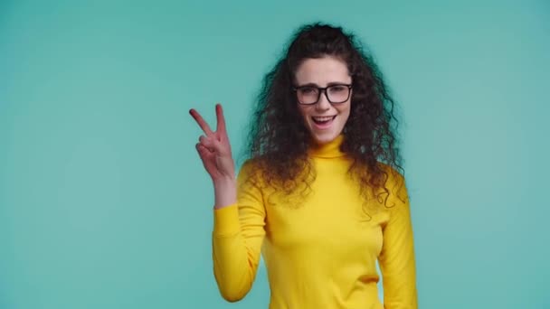 Glimlachende Vrouw Tonen Vrede Geïsoleerd Turquoise — Stockvideo