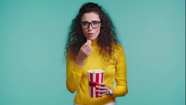 Chockad Kvinna Äter Popcorn Isolerad Turkos — Stockvideo