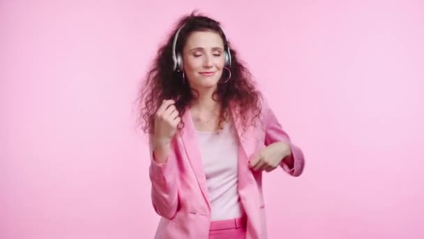 Sonriente Mujer Con Auriculares Bailando Aislado Rosa — Vídeos de Stock