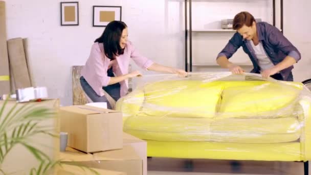 Cheerful Couple Unpacking Couch New Home — Stock Video