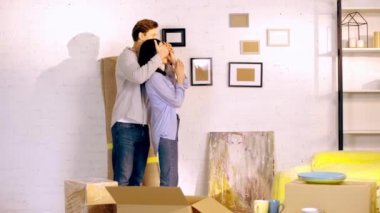 Man surprising girlfriend near boxes in new home 