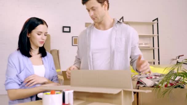 Young Couple Laughing While Packing Boxes Living Room — Stockvideo