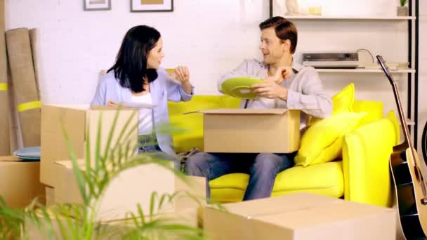 Paar Verpackt Teller Pakete Auf Couch — Stockvideo