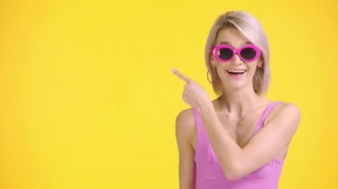 Mutlu kız parmağıyla işaret ediyor ve parmaklarını sarının üzerinde gösteriyor.