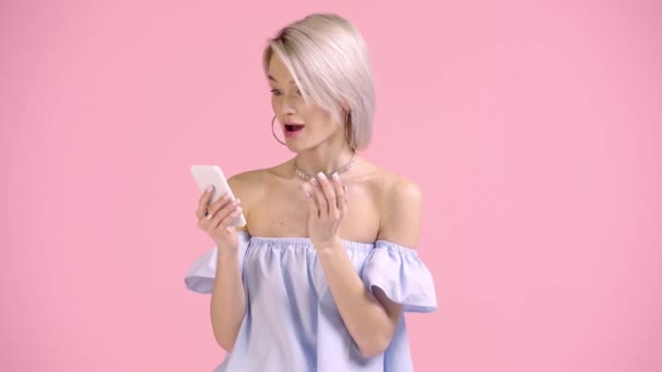 Heureux Fille Pointant Doigt Smartphone Montrant Isolé Sur Rose — Video