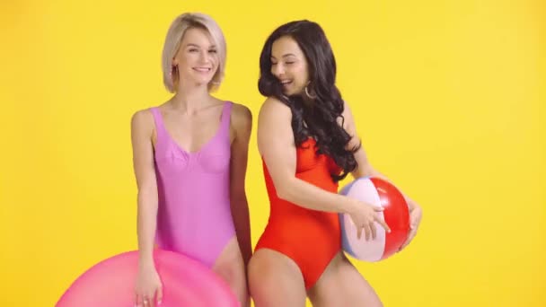 Chicas Sonrientes Trajes Baño Posando Desapareciendo Aisladas Amarillo — Vídeo de stock