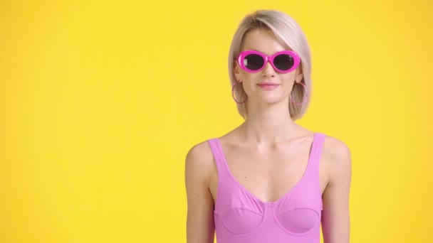 Alegre Chica Traje Baño Gafas Sol Agitando Mano Aislado Amarillo — Vídeos de Stock