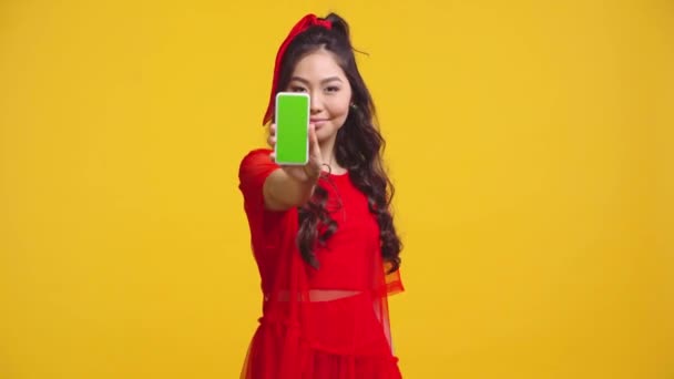 Asiatico Ragazza Holding Smartphone Con Verde Schermo Isolato Giallo — Video Stock