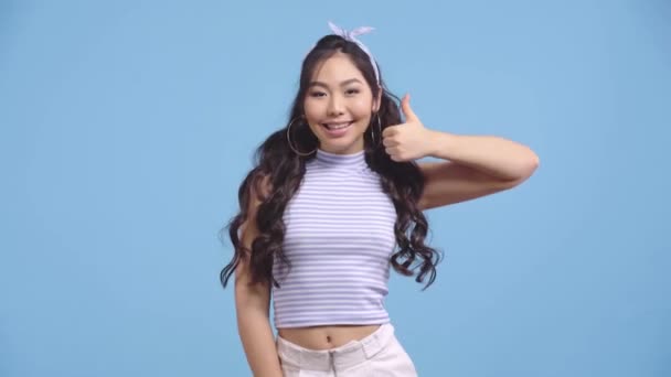 Happy Asian Girl Showing Thumb Isolated Blue — Stock Video