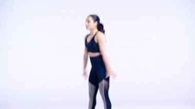 Genç sportif kız beyazların üzerine çömeliyor. 