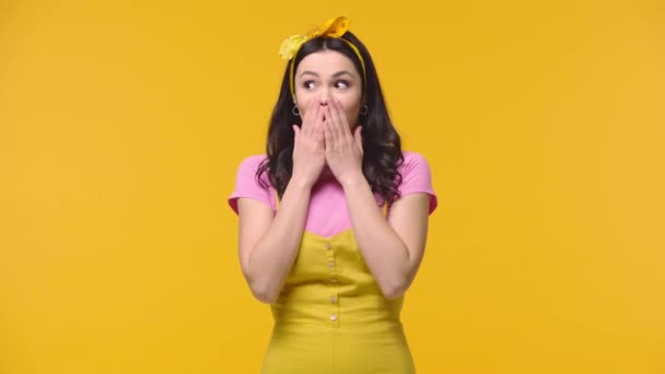 Podekscytowana Kobieta Zakrywająca Usta Izolowaną Żółto — Wideo stockowe