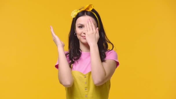 顔をカバーし 手を振って興奮した女性は黄色に隔離 — ストック動画