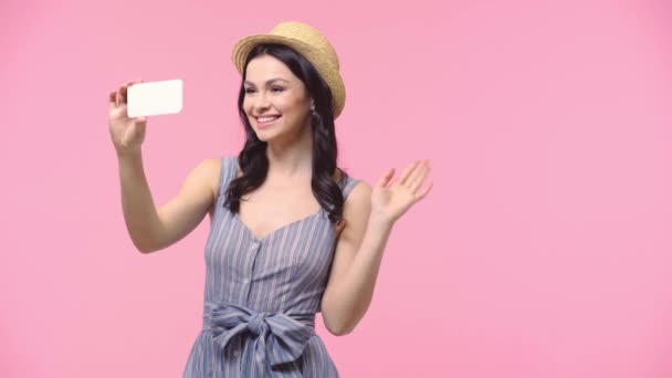 Mujer Saludando Mano Sonriendo Mientras Toma Selfie Aislado Rosa — Vídeo de stock