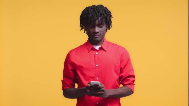 Αφροαμερικάνος Που Μιλάει Στο Smartphone Και Χαμογελά Απομονωμένος Στο Κίτρινο — Αρχείο Βίντεο