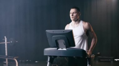 Spor salonunda koşu bandında koşan atletik adam. 