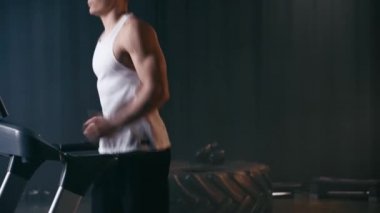 Koşu bandında koşan sportif adamın kırpılmış görüntüsü 