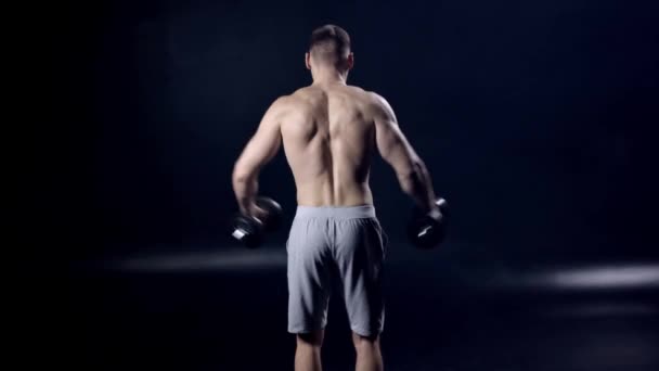 Rückenansicht Eines Mannes Der Mit Kurzhanteln Auf Schwarz Trainiert — Stockvideo