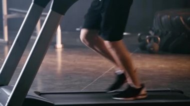 Spor salonunda koşu bandında koşan sporcu manzarası. 