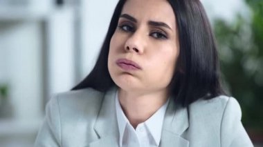 Ofisteki kameraya bakan hoşnutsuz iş kadını 