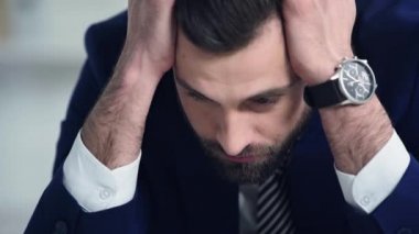 üzgün işadamı ofisin başına dokunuyor 