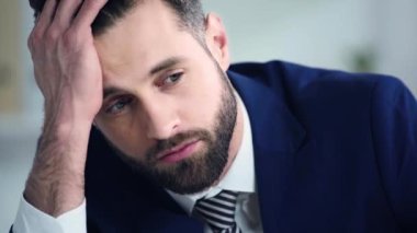 üzgün işadamı ofisteki kameraya bakıyor 
