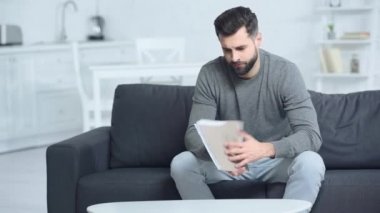 Evde dosyasına dokunan stresli bir adam. 