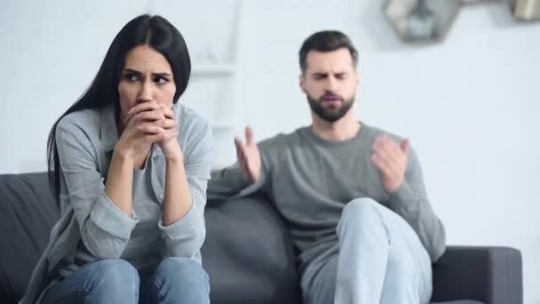 心烦意乱的女人坐在不高兴的男朋友身边的选择性焦点 — 图库视频影像