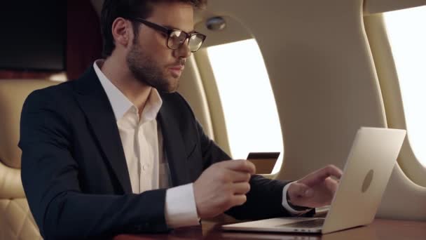 Obchodník Pomocí Notebooku Držení Kreditní Karty Při Cestování Letadlem — Stock video