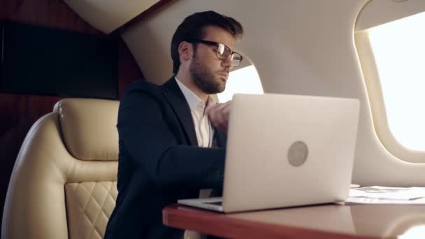 Hombre Negocios Serio Escribiendo Ordenador Portátil Hablando Teléfono Inteligente Avión — Vídeos de Stock